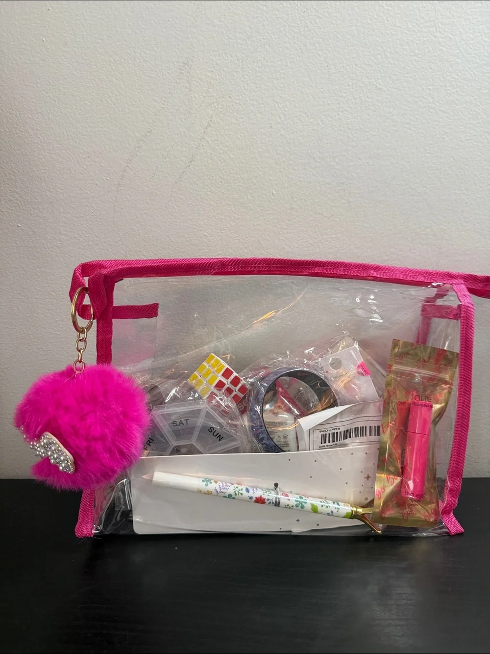 Clear Cosmetic Pouch with Hot Pink Trim and Pom Charm filled with goodies